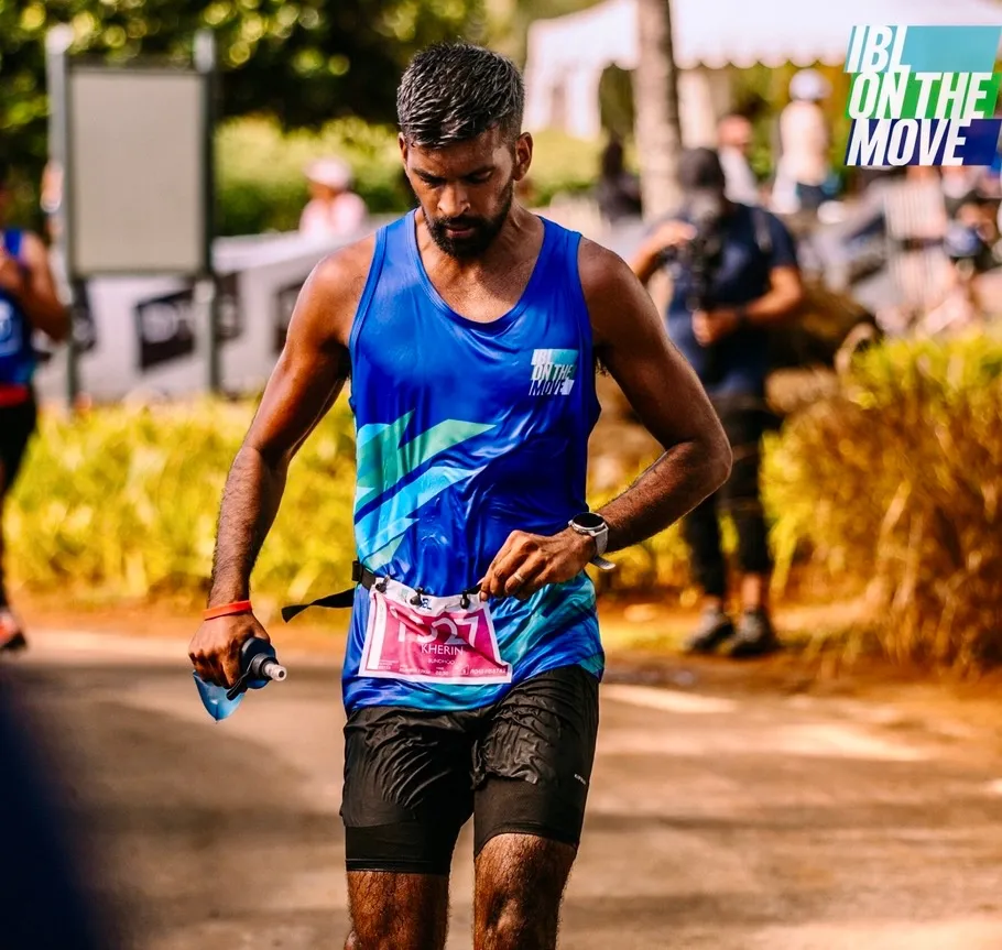 Kherin running a daytime trail race through tropical vegetation